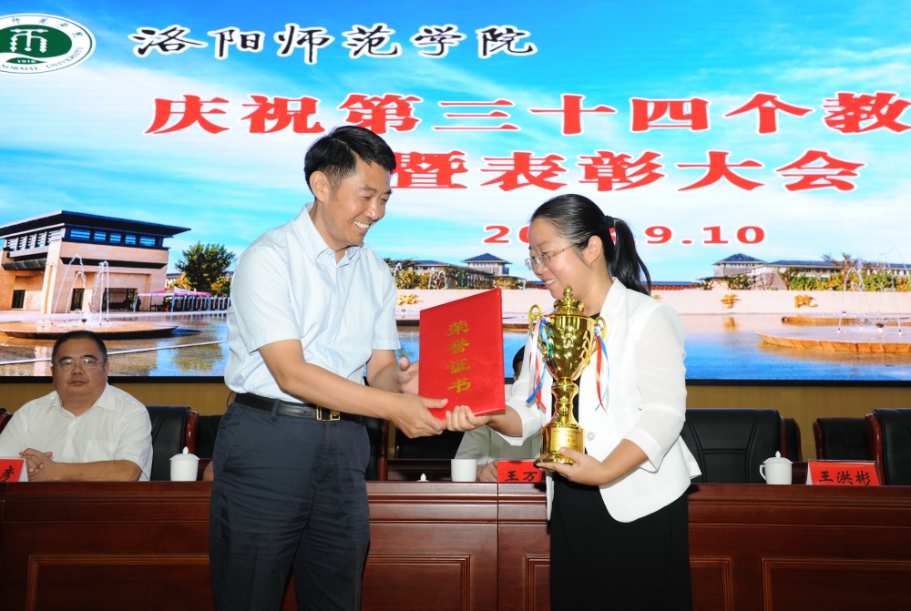 校党委书记王洪彬为受表彰教师颁发获奖证书
